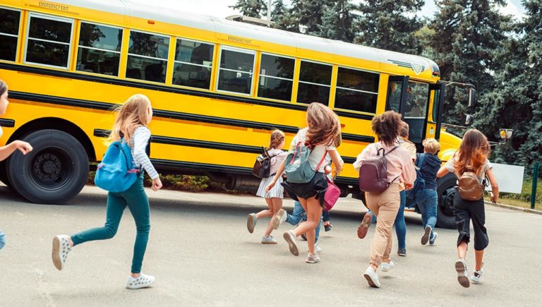 kids running towards school bus